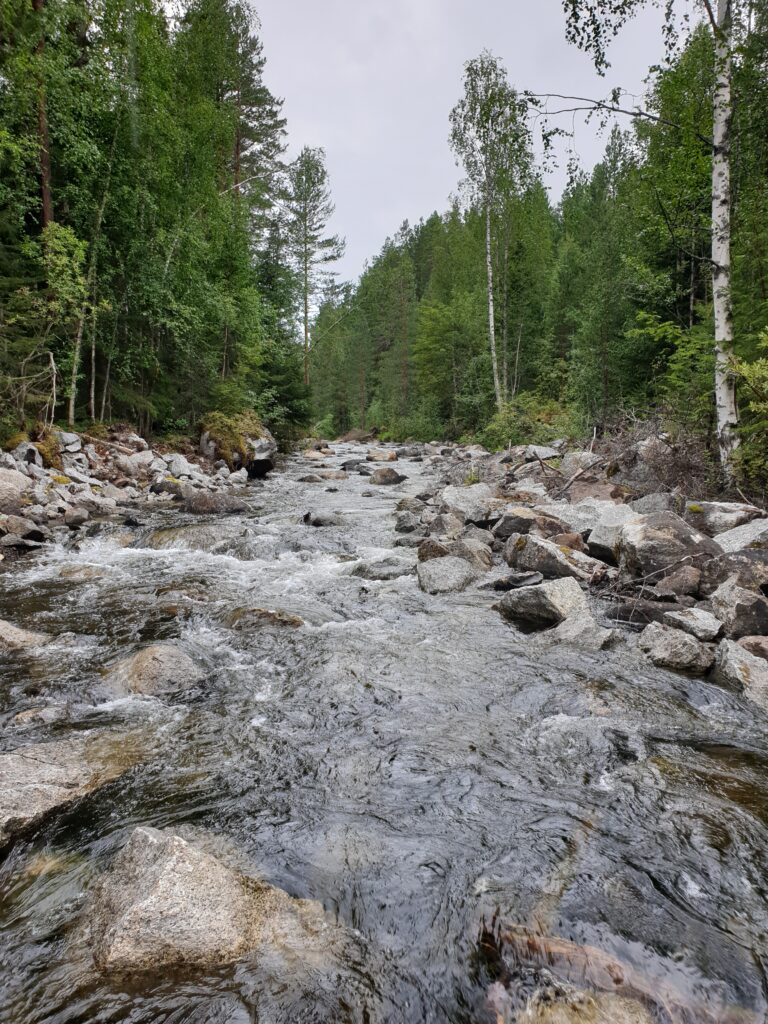 Flottledsrensat vattendrag med mycket rester av sprängda block längs sidorna på vattendraget.