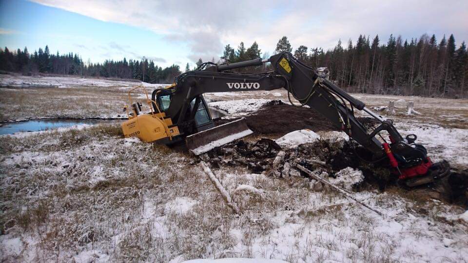 Excavator partially sunk in the shoreline zone.